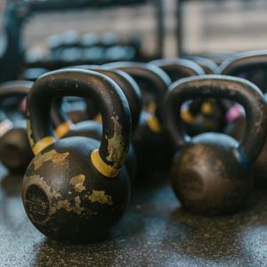 Close-up on a kettlebell resting on a gym floor.