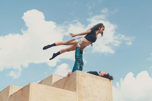 Man performing a controlled bodyweight exercise in a minimalist space.
