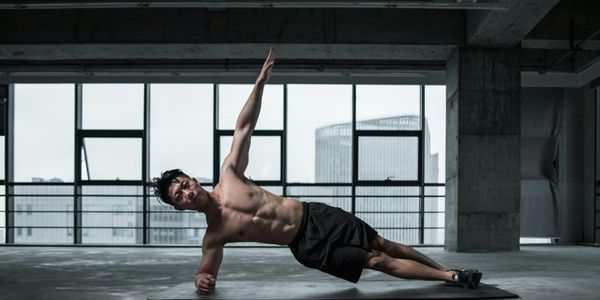 Side view of a man holding a plank position.